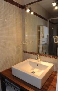 ein Badezimmer mit einem weißen Waschbecken und einem Spiegel in der Unterkunft La closeraie 