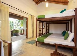 a bedroom with two bunk beds and a balcony at KayJay Palms in Pasikuda