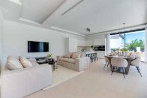 een woonkamer met witte meubels en een eetkamer bij VACATION MARBELLA I Villa Monte Halcones, Private-Pool, Brand-New, Incredible Views, Near Golf Valley in Benahavís