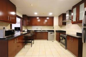 a large kitchen with wooden cabinets and appliances at JBR The Walk Rimal 5 Suites High Floor 3 Bedroom in Dubai