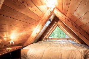 Bett in einem Holzzimmer mit Fenster in der Unterkunft Rustico Savinera - Happy Rentals in San Carlo