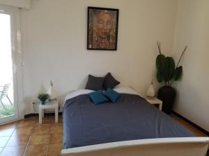 ein Schlafzimmer mit einem Bett mit einer blauen Decke in der Unterkunft Belle villa classée 4 étoiles proche plage avec jardin in Saint Cyprien Plage
