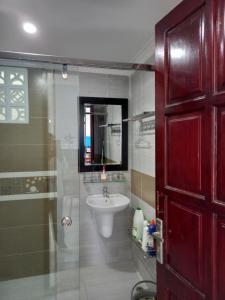 uma casa de banho com um chuveiro, um lavatório e um espelho. em Trump Homestay em Ấp Lò Gốm