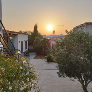 einen Blick auf den Sonnenuntergang von einem Hof mit Häusern in der Unterkunft The Family Nest - Traditional Serenity in Nikosia