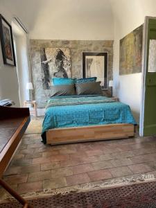 a bedroom with a bed with a blue comforter at Magnifique gîte 75M2 avec terrasse 30m2, piscine, terrain de pétanque, et jardin en Cévennes in Meyrannes