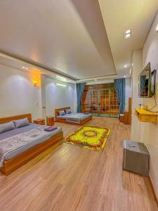 een grote slaapkamer met 2 bedden en een tapijt bij Nhan Tay 2 Hotel in Can Tho