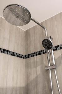 a shower with a shower head in a bathroom at La Cle des Expos "In Paris" in Vanves