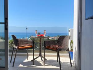 a table and chairs on a balcony with a view of the ocean at Green Door Getaway in Limassol