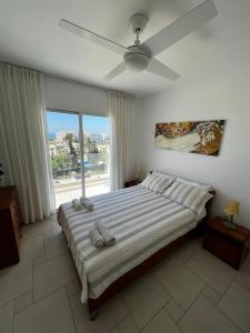 a bedroom with a large bed with a ceiling fan at Green Door Getaway in Limassol