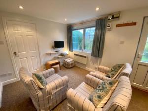 a living room with two couches and a tv at Seagull Leigh Cottages in Seaton