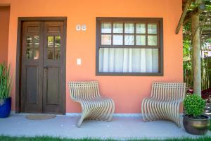 zwei Stühle vor einem Haus mit einer Tür in der Unterkunft Meu Paraíso em Búzios in Búzios