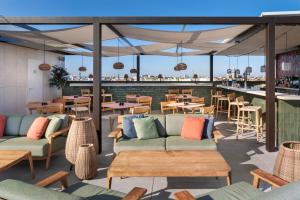 un patio con sofás y mesas y un bar en Catalonia Santa Justa, en Sevilla