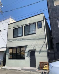 un bâtiment blanc avec une porte noire dans une rue dans l'établissement Yaizu - House - Vacation STAY 14728, à Yaizu