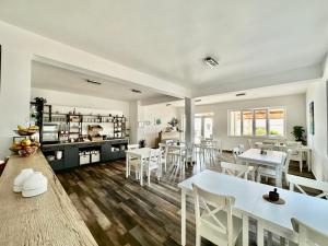 una sala da pranzo con tavoli bianchi e sedie bianche di Pansion Braco a Zavala