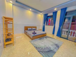 a bedroom with two beds with blue curtains at Nhan Tay 2 Hotel in Can Tho