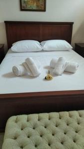 un letto con tre asciugamani e un orologio sopra di Fairytale apartment ad Agios Ioannis