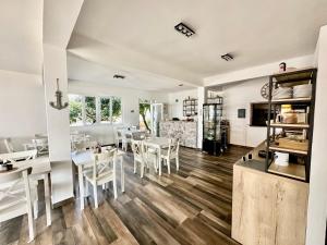 a dining room with white tables and white chairs at Pansion Braco in Zavala