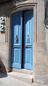 dos puertas azules en el lateral de un edificio en International Hostel Lapplandia B&B., en Vigo