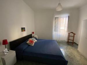 a bedroom with a blue bed and a window at Dimora Zefiro vacanze in Gioiosa Marea