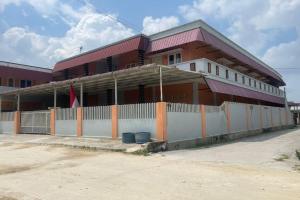 un gran edificio con una valla delante en OYO 92924 Kalista Guest House Syariah, en Pekanbaru