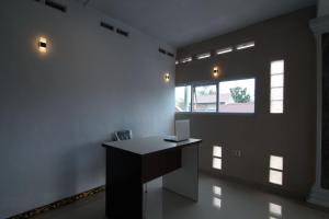 una oficina con escritorio en una habitación con ventana en OYO 92924 Kalista Guest House Syariah, en Pekanbaru