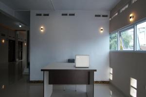 Habitación con mesa y ordenador portátil. en OYO 92924 Kalista Guest House Syariah, en Pekanbaru