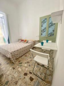 una camera con letto, tavolo e sedia di Dimora Zefiro vacanze a Gioiosa Marea