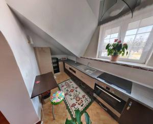 eine Küche im Dachgeschoss mit einem Tisch und einem Fenster in der Unterkunft Modern 3-bedroom place in Ramnicu Valcea in Râmnicu Vâlcea