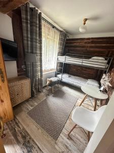 a bedroom with a bunk bed and a desk and a table at Osada Barbanica in Szczyrk