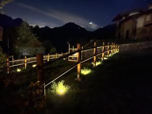 una cerca con luces en un campo por la noche en Baitèl de Sòt e Sura - Appartamenti en Gromo