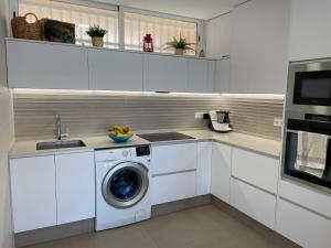 una cocina blanca con lavadora. en Beach House Relax en Gran Alacant