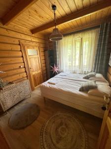 una camera con un grande letto in una baita di tronchi di Osada Barbanica a Szczyrk