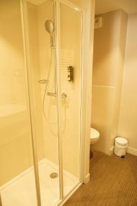 a shower stall in a bathroom with a toilet at Hotel Le Faranchin in Villar-dʼArène
