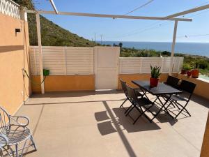 um pátio com uma mesa e cadeiras e o oceano em Beach House Relax em Gran Alacant