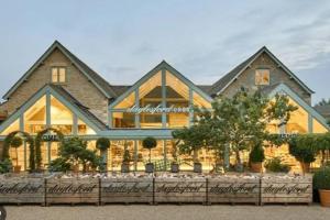 a large house with a fence in front of it at Luxury Barn near Soho Farmhouse in Middle Barton