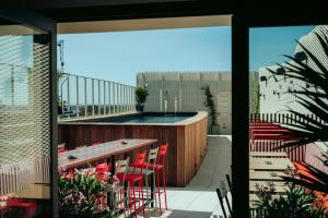 balkon z czerwonymi krzesłami i basenem w obiekcie JOST Hostel Montpellier Centre St Roch w Montpellier
