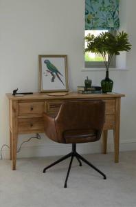 een houten bureau met een stoel in een kamer bij Luxury Barn near Soho Farmhouse in Middle Barton