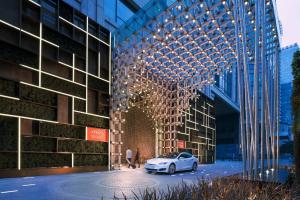 um carro branco estacionado em frente a um edifício em Canopy by Hilton Chengdu City Centre em Chengdu