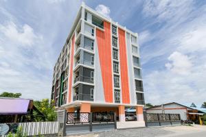 an apartment building with an orange stripe on it at The Wish Hotel in Chachoengsao