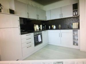 uma cozinha com armários brancos e um forno com placa de fogão em Ferienwohnung App 256 em Braunlage