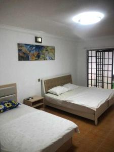 a bedroom with two beds and a painting on the wall at Sea Inn Guesthouse Sihanoukville in Sihanoukville