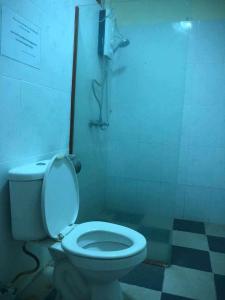 a bathroom with a white toilet and a shower at Sea Inn Guesthouse Sihanoukville in Sihanoukville