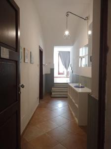 pasillo de un baño con lavabo y ventana en appartamento in Borgo storico., en Pontremoli