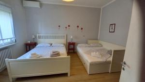 a bedroom with two beds and two windows at B&B Nadine Forlì - boutique eco stay con parcheggio gratuito in Forlì