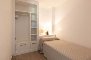um pequeno quarto com 2 camas e um closet em Loft Los Caracoles em Palamós