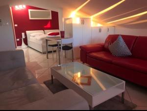 - un salon avec un canapé rouge et une table dans l'établissement Apartments Villa Lili, à Umag