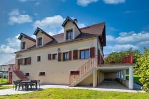 a large house with a balcony and a table at La Petite Chalautrière - Avec grand jardin in Chalautre-la-Petite