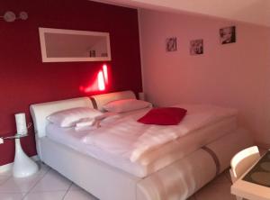 a bedroom with a white bed with red lights at Apartments Villa Lili in Umag