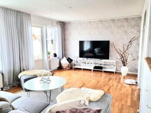 sala de estar con sofá y TV en Hus i lugnt område, 15 min från Örebro en Vintrosa