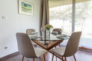 comedor con mesa de cristal y sillas en Apartment Rosemary, en Topolšica